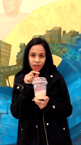 This is a moving image of Aliya drinking a Tim Horton's ice cap.