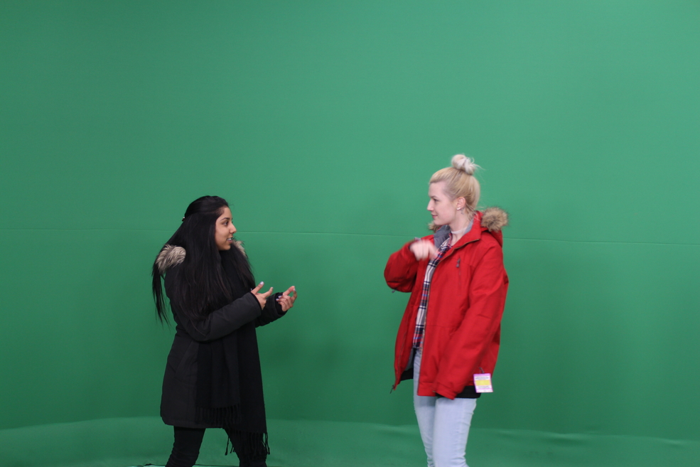 Celeena and a friend in front of a green screen