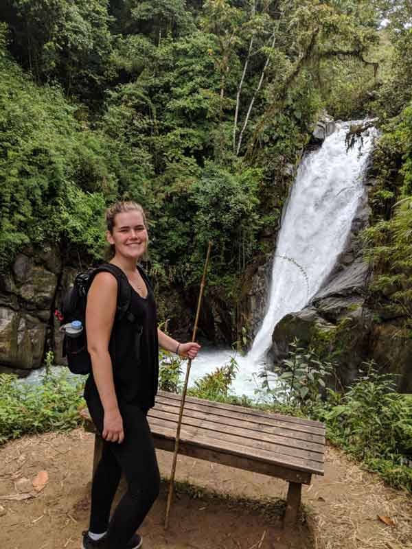 Christina standing beside a waterfall in Costa Rica